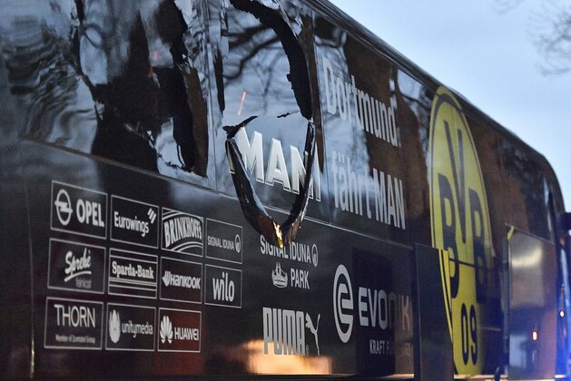 FILE - In this April 11, 2017 file photo a window of Dortmund's team bus is damaged after an explosion before the Champions League quarterfinal soccer match between Borussia Dortmund and AS Monaco in Dortmund, Germany. On Thursday, Dec. 21, 2017 a man will go on trial. He is charged with the attempted murder of Borussia's soccer team by detonating homemade bombs when traveling to the match.  (AP Photo/Martin Meissner,file)