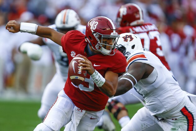 Alabama quarterback Tua Tagovailoa (13) escapes pressure from Auburn defensive lineman Marlon Davidson (3) during the first half of an NCAA college football game, Saturday, Nov. 24, 2018, in Tuscaloosa, Ala. (AP Photo/Butch Dill)