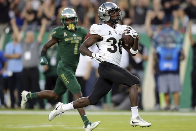 Central Florida's Greg McCrae runs past South Florida's Mike Hampton to score a touchdown during the first half of an NCAA college football game Friday, Nov. 23, 2018, in Tampa, Fla. (AP Photo/Mike Carlson)