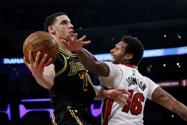 Los Angeles Lakers guard Lonzo Ball, left, goes to the basket while defended by Miami Heat forward James Johnson during the second half of an NBA basketball game Friday, March 16, 2018, in Los Angeles. The Heat won 92-91. (AP Photo/Ringo H.W. Chiu)