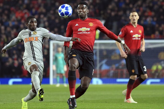 ManU midfielder Paul Pogba vies for the ball with Young Boys' Roger Assale, left, during the Champions League group H soccer match between Manchester United and Young Boys at Old Trafford Stadium in Manchester, England, Tuesday Nov. 27, 2018. (AP Photo/Jon Super)