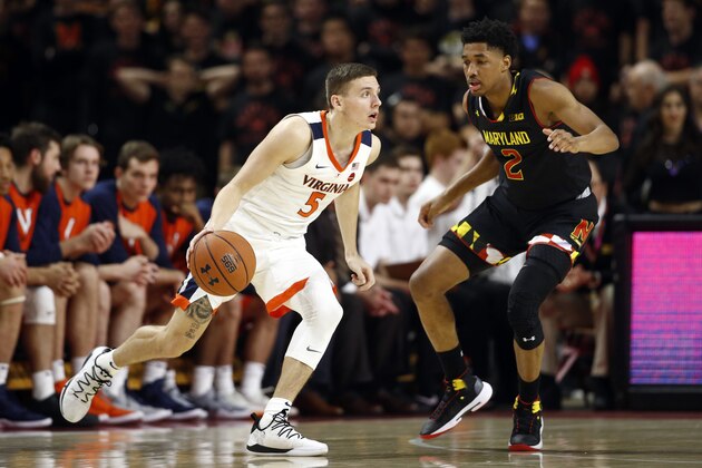 Virginia guard Kyle Guy, left, drives around Maryland guard Aaron Wiggins during the second half of an NCAA college basketball game Wednesday, Nov. 28, 2018, in College Park, Md. (AP Photo/Patrick Semansky)