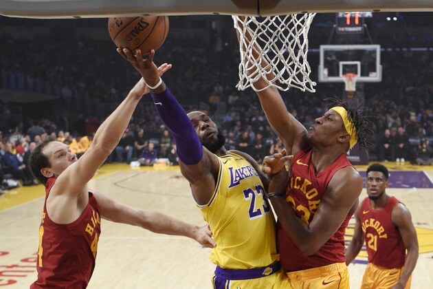 Los Angeles Lakers forward LeBron James, center, shoots as Indiana Pacers forward Bojan Bogdanovic, left, of Croatia, and center Myles Turner defend during the first half of an NBA basketball game Thursday, Nov. 29, 2018, in Los Angeles. (AP Photo/Mark J. Terrill)