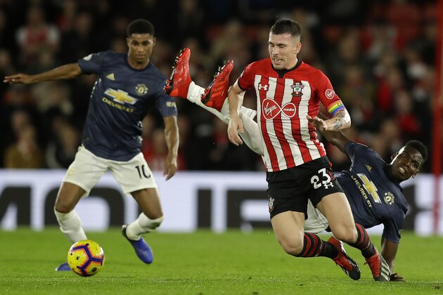 Manchester United's Paul Pogba, right, fights for the ball with Southampton's Pierre-Emile Hojbjerg, center, during the English Premier League soccer match between Southampton and Manchester United at St Mary's stadium in Southampton, England Saturday, Dec. 1, 2018. (AP Photo/Kirsty Wigglesworth)