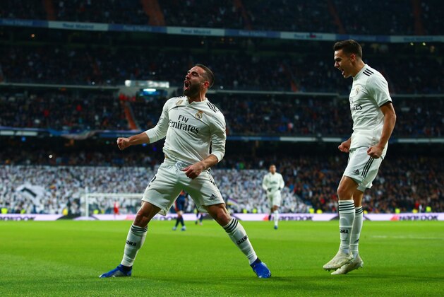 MADRID, SPAIN - DECEMBER 01:  Daniel Carvajal of Real Madrid (L) celebrates with Sergio Reguilon as Daniel Wass of Valencia scores an own goal for their first goal during the La Liga match between Real Madrid CF and Valencia CF at Estadio Santiago Bernabeu on December 01, 2018 in Madrid, Spain. (Photo by Gonzalo Arroyo Moreno/Getty Images)
