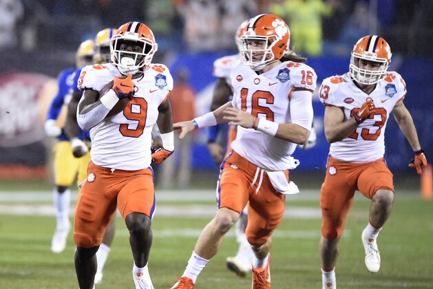 Clemson's Travis Etienne (9) runs for a touchdown against Pittsburgh as Trevor Lawrence (16) follows in the first half of the Atlantic Coast Conference championship NCAA college football game in Charlotte, N.C., Saturday, Dec. 1, 2018. (AP Photo/Mike McCarn)