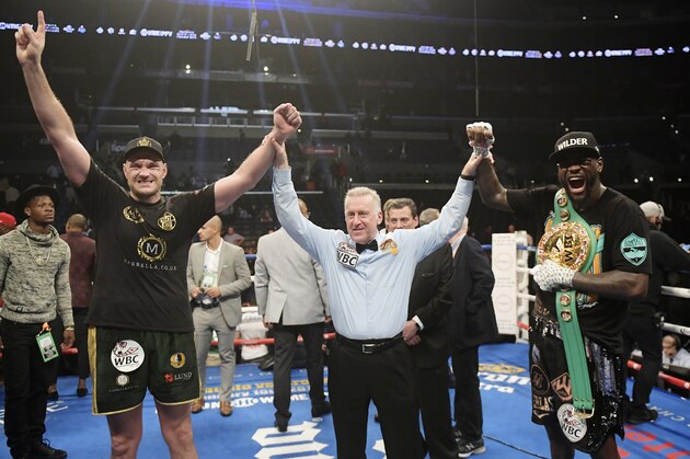 Tyson Fury, left, of England, poses with Deontay Wilder, right, along with referee Jack Reiss after their WBC heavyweight championship boxing match ended in a draw, Saturday, Dec. 1, 2018, in Los Angeles. (AP Photo/Mark J. Terrill)