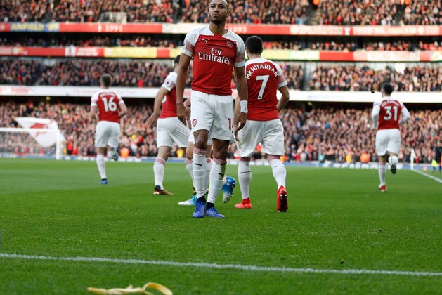 A banana thrown from the crowd is seen at the side of the pitch as Arsenal's Gabonese striker Pierre-Emerick Aubameyang (C) celebrates after scoring the opening goal from the penalty spot during the English Premier League football match between Arsenal and Tottenham Hotspur at the Emirates Stadium in London on December 2, 2018. (Photo by Ian KINGTON / IKIMAGES / AFP) / RESTRICTED TO EDITORIAL USE. No use with unauthorized audio, video, data, fixture lists, club/league logos or 'live' services. Online in-match use limited to 45 images, no video emulation. No use in betting, games or single club/league/player publications.        (Photo credit should read IAN KINGTON/AFP/Getty Images)