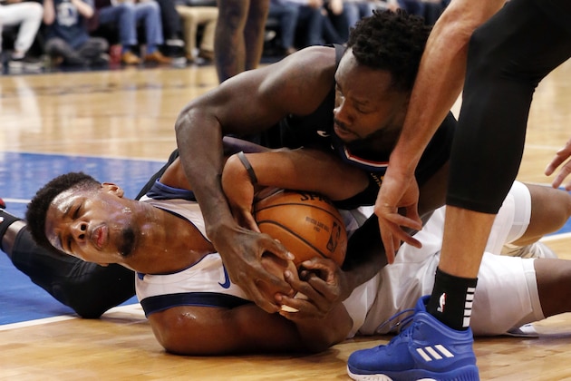 Dallas Mavericks guard Dennis Smith Jr. (1) fights for the ball with Los Angeles Clippers guard Patrick Beverley (21) during the second half of an NBA basketball game in Dallas, Sunday, Dec. 2, 2018. Smith Jr. lost a tooth on the play. Dallas won 114-110. (AP Photo/Michael Ainsworth)