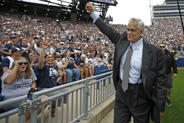 FILE - In this Sept. 1, 2018, file photo, honorary captain and Penn State alumn Matt Millen waves to the crowd before the team takes on Appalachian State in an NCAA college football game in State College, Pa. Millen is stepping away from his TV analyst job for the rest of this season to focus on his health. The Big Ten Network made the announcement Wednesday, Oct. 3, 2018. The 60-year Millen has amyloidosis and has been seeking a heart transplant. (AP Photo/Chris Knight, File)