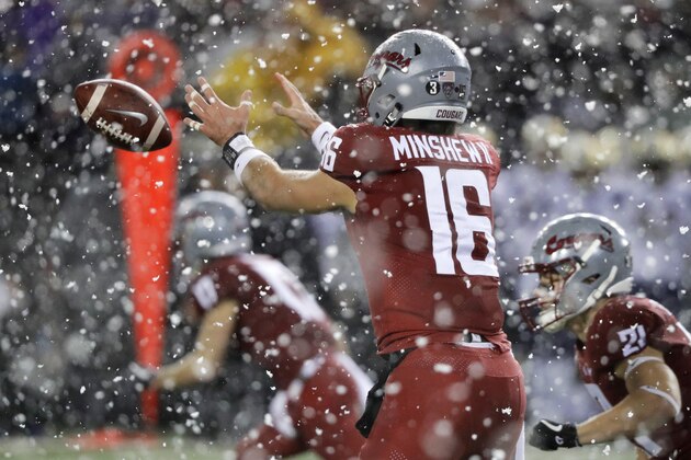 Washington State quarterback Gardner Minshew takes a snap as snow falls during the first half of an NCAA college football game against Washington, Friday, Nov. 23, 2018, in Pullman, Wash. (AP Photo/Ted S. Warren)