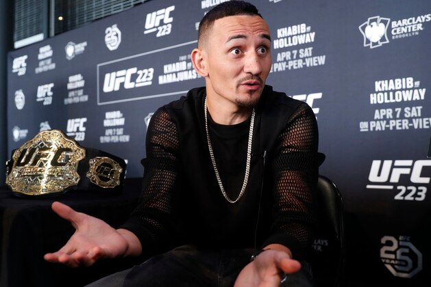 FILE - In this Thursday, April 5, 2018, file photo, UFC featherweight champion Max Holloway gestures while responding to reporters' questions during Media Day for UFC 223 at the Barclays Center in New York, ahead of his upcoming lightweight title fight against Khabib Nurmagomedov. Holloway has failed to make weight, canceling the main event of UFC 223 and adding further upheaval to the promotion following criminal charges against star Conor McGregor. Holloway agreed to fight Khabib Nurmagomedov on Saturday on just six days' notice after original challenger Tony Ferguson injured a knee. But Holloway was unable to reach the weight limit for the bout Friday and was ruled out by the UFC medical team. There was no immediate word if a replacement fighter would face Nurmagomedov. (AP Photo/Kathy Willens, File)