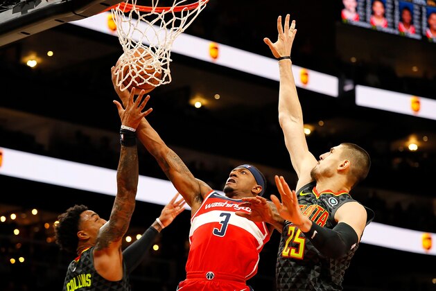 ATLANTA, GA - DECEMBER 05:  Bradley Beal #3 of the Washington Wizards drives between John Collins #20 and Alex Len #25 of the Atlanta Hawks at State Farm Arena on December 5, 2018 in Atlanta, Georgia.  NOTE TO USER: User expressly acknowledges and agrees that, by downloading and or using this photograph, User is consenting to the terms and conditions of the Getty Images License Agreement.  (Photo by Kevin C. Cox/Getty Images)