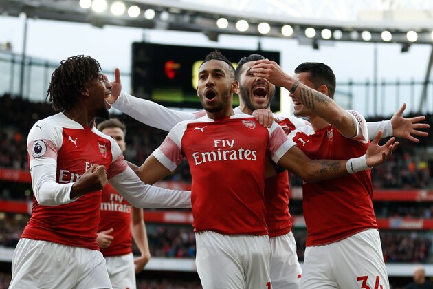Arsenal's Gabonese striker Pierre-Emerick Aubameyang (C) celebrates after scoring the opening goal from the penalty spot during the English Premier League football match between Arsenal and Tottenham Hotspur at the Emirates Stadium in London on December 2, 2018. (Photo by Ian KINGTON / IKIMAGES / AFP) / RESTRICTED TO EDITORIAL USE. No use with unauthorized audio, video, data, fixture lists, club/league logos or 'live' services. Online in-match use limited to 45 images, no video emulation. No use in betting, games or single club/league/player publications.        (Photo credit should read IAN KINGTON/AFP/Getty Images)