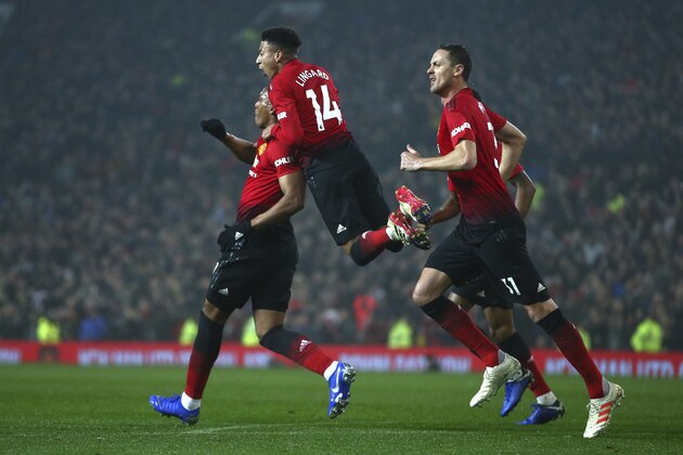 Manchester United's midfielder Jesse Lingard, center, jumps on the shoulders of teammate Anthony Martial who scored his side's first goal during the English Premier League soccer match between Manchester United and Arsenal at Old Trafford stadium in Manchester, England, Wednesday Dec. 5, 2018. (AP Photo/Dave Thompson)