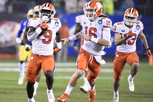 Clemson's Travis Etienne (9) runs for a touchdown against Pittsburgh as Trevor Lawrence (16) follows in the first half of the Atlantic Coast Conference championship NCAA college football game in Charlotte, N.C., Saturday, Dec. 1, 2018. (AP Photo/Mike McCarn)