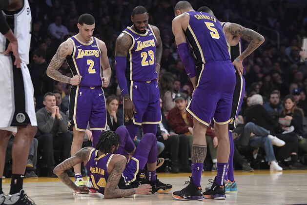 Los Angeles Lakers forward Brandon Ingram, below, lies on the floor after being injured as teammates Lonzo Ball, LeBron James, Tyson Chandler and Kyle Kuzma stand over him during the first half of an NBA basketball game against the San Antonio Spurs, Wednesday, Dec. 5, 2018, in Los Angeles. (AP Photo/Mark J. Terrill)