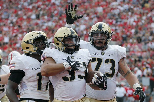 FILE - In this Sept. 16, 2017, file photo, Army running back Darnell Woolfolk, center, celebrates his touchdown against Ohio State with teammates Ahmad Bradshaw, left, and Jaxson Deaton during the first half of an NCAA college football game in Columbus, Ohio. Army travels to Air Force to face the Falcons Saturday. (AP Photo/Jay LaPrete, File)