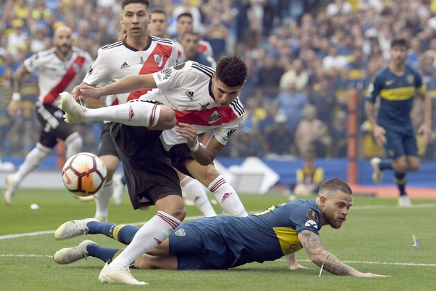 Exequiel Palacios of Argentina's River Plate, front, fights for the ball with Nahitan Nandez of Argentina's Boca Juniors, down, during the first leg soccer match of the Copa Libertadores final in Buenos Aires, Argentina, Sunday, Nov. 11, 2018. (AP Photo/Gustavo Garello)