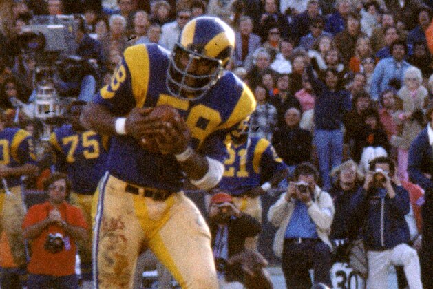 LOS ANGELES - DECEMBER 22:  Linebacker Isiah Robertson #58 of the Los Angeles Rams intercpets a pass intended for runinng back Larry Brown #43 of the Washington Redskins that he'll return 59-yards for a touchdown in the 1974 NFC Divisional Playoff Game at the Los Angeles Memorial Coliseum in Los Angeles, California on December 22, 1974.  The Rams defeated the Redskins 19-10. (Photo by Nate Fine/Getty Images)