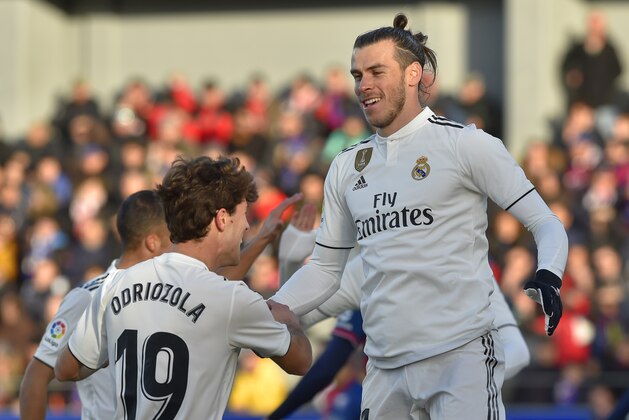 Real Madrid's Welsh forward Gareth Bale (R) is congratulated by teammate defender Alvaro Odriozola during the Spanish league football match between SD Huesca and Real Madrid CF at the El Alcoraz stadium on December 9, 2018. (Photo by ANDER GILLENEA / AFP)        (Photo credit should read ANDER GILLENEA/AFP/Getty Images)