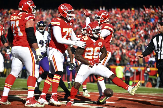 Kansas City Chiefs running back Damien Williams (26) celebrates a touchdown with teammate offensive guard Cameron Erving (75) during the first half of an NFL football game against the Baltimore Ravens in Kansas City, Mo., Sunday, Dec. 9, 2018. (AP Photo/Ed Zurga)