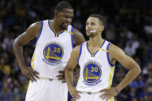 FILE - In this Oct. 4, 2016, file photo, Golden State Warriors' Kevin Durant, left, speaks with Stephen Curry (30) during the first half of a pre-season NBA basketball game against the Los Angeles Clippers in Oakland, Calif. For everyone who questioned whether Stephen Curry and Kevin Durant could coexist and put their egos aside for the greater good, the Golden State Warriors are a couple of months into the season and the superstars are thriving together. (AP Photo/Ben Margot)