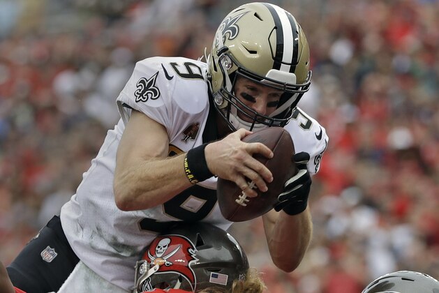New Orleans Saints quarterback Drew Brees (9) dives over Tampa Bay Buccaneers defensive tackle Beau Allen (91) to score on a 1-yard touchdown run during the second half of an NFL football game Sunday, Dec. 9, 2018, in Tampa, Fla. (AP Photo/Mark LoMoglio)