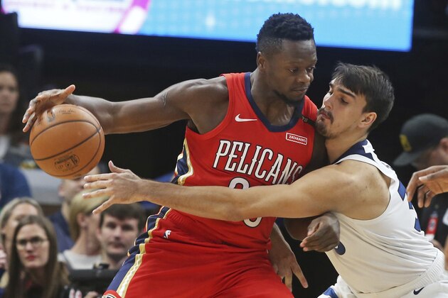 Newly acquired Minnesota Timberwolves' Dario Saric, right, of Croatia, tries to reach the ball as New Orleans Pelicans' Julius Randle keeps it at arm's length in the first half of an NBA basketball game Wednesday, Nov. 14, 2018, in Minneapolis. (AP Photo/Jim Mone)