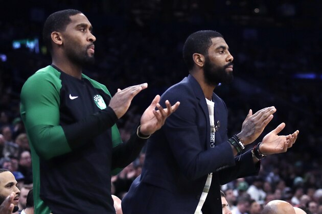 Boston Celtics guard Kyrie Irving, right, who did not play due to an injury, and guard Brad Wanamaker, left, applaud teammates during the first quarter of a basketball game against the New Orleans Pelicans in Boston, Monday, Dec. 10, 2018. (AP Photo/Charles Krupa)