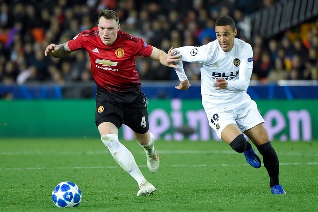 Manchester United's English defender Phil Jones (L) challenges Valencia's Spanish forward Rodrigo Moreno during the UEFA Champions League group H football match between Valencia CF and Manchester United at the Mestalla stadium in Valencia on December 12, 2018. (Photo by JOSE JORDAN / AFP)        (Photo credit should read JOSE JORDAN/AFP/Getty Images)