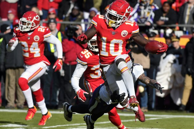 FILE - In this Dec. 9, 2018, file photo, Kansas City Chiefs wide receiver Tyreek Hill (10) runs past a tackle attempt by Baltimore Ravens' Chris Moore, rear, during the first half of an NFL football game in Kansas City, Mo. Hill walked off the field holding his wrist Sunday and Chiefs fans held their collective breath, only to exhale when their star wide receiver checked back into the game.  They held it again when Hill hobbled to the sideline with a foot injury.  But in a back-and-forth game with significant playoff ramifications, there was no way Hill was going to stay there. He limped back into the game in time to catch Patrick Mahomes’ 40-yard heave on fourth-and-long to keep the Chiefs alive, then caught three more passes in overtime _ all for first downs _ to set the Chiefs up for the eventual winning field goal against Baltimore.  (AP Photo/Ed Zurga, File)