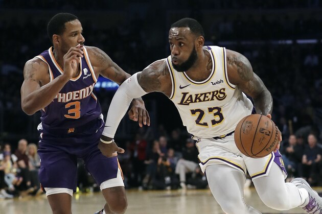 Los Angeles Lakers' LeBron James (23) dribbles next to Phoenix Suns' Trevor Ariza (3) during the second half of an NBA basketball game Sunday, Dec. 2, 2018, in Los Angeles. (AP Photo/Marcio Jose Sanchez)