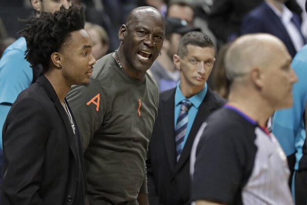 Charlotte Hornets owner Michael Jordan, center, shouts at an official in the final seconds of the second half of an NBA basketball game against the Detroit Pistons in Charlotte, N.C., Wednesday, Dec. 12, 2018. Officials ruled the Hornets had six players on the floor in the final second of the game, giving one free throw to Detroit. The Hornets won 108-107. (AP Photo/Chuck Burton)
