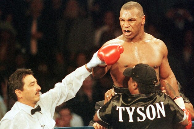 Boxer Mike Tyson of the United States (top R) exhorts Andrew Golota of Poland (not pictured) to continue fighting as referee Frank Garza Jr. raises his hand awarding him a TKO after Golota refused to answer the bell for the third round of their fight at the Palace of Auburn Hills, Michigan, 20 October 2000. This is Tyson's 49th victory in his career.  AFP PHOTO  Daniel Lippitt (Photo credit should read DANIEL LIPPITT/AFP/Getty Images)