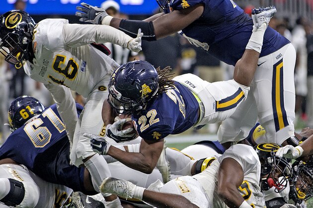 North Carolina A&T's Marquell Cartwright (22) dives through the Grambling State defense during the Celebration Bowl NCAA college football game Saturday, Dec. 16, 2017, in Atlanta. (Andrew Krech/News & Record via AP)