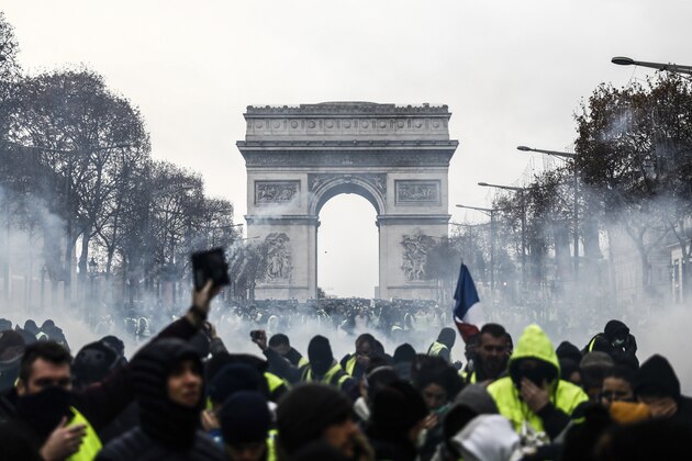 Protesters wearing yellow vests (gilets jaunes) demonstrate against rising costs of living they blame on high taxes near the Arc de Triomphe on the Champs-Elysees avenue in Paris, on December 8, 2018. - The 'yellow vest' movement in France originally started as a protest about planned fuel hikes but has morphed into a mass protest against President's policies and top-down style of governing. (Photo by Sameer Al-Doumy / AFP)        (Photo credit should read SAMEER AL-DOUMY/AFP/Getty Images)