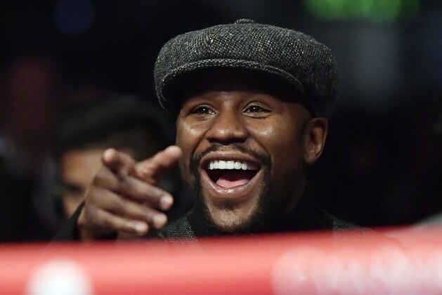 Boxer Floyd Mayweather points to someone in the crowd as he watches a boxing match between Deontay Wilder and Tyson Fury, of England, for the WBC heavyweight championship, Saturday, Dec. 1, 2018, in Los Angeles. (AP Photo/Mark J. Terrill)