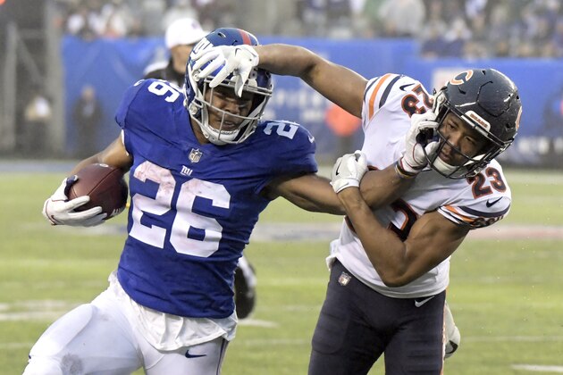 New York Giants running back Saquon Barkley (26) stiff arms Chicago Bears cornerback Kyle Fuller (23) during the second half of an NFL football game, Sunday, Dec. 2, 2018, in East Rutherford, N.J. (AP Photo/Bill Kostroun)