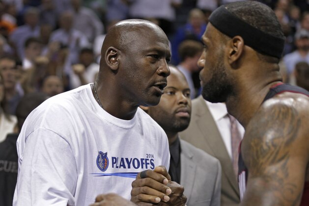 Charlotte Bobcats owner Michael Jordan, left, shakes hands with Miami Heat's LeBron James, right, after Game 4 of an opening-round NBA basketball playoff series in Charlotte, N.C., Monday, April 28, 2014. The Heat won 109-98, sweeping the series. (AP Photo/Chuck Burton)