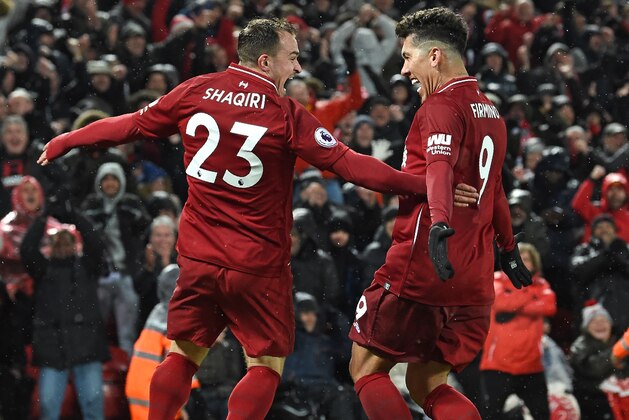 Liverpool's Swiss midfielder Xherdan Shaqiri celebrates with Liverpool's Brazilian midfielder Roberto Firmino (R) after scoring their third goal during the English Premier League football match between Liverpool and Manchester United at Anfield in Liverpool, north west England on December 16, 2018. (Photo by Paul ELLIS / AFP) / RESTRICTED TO EDITORIAL USE. No use with unauthorized audio, video, data, fixture lists, club/league logos or 'live' services. Online in-match use limited to 120 images. An additional 40 images may be used in extra time. No video emulation. Social media in-match use limited to 120 images. An additional 40 images may be used in extra time. No use in betting publications, games or single club/league/player publications. /         (Photo credit should read PAUL ELLIS/AFP/Getty Images)