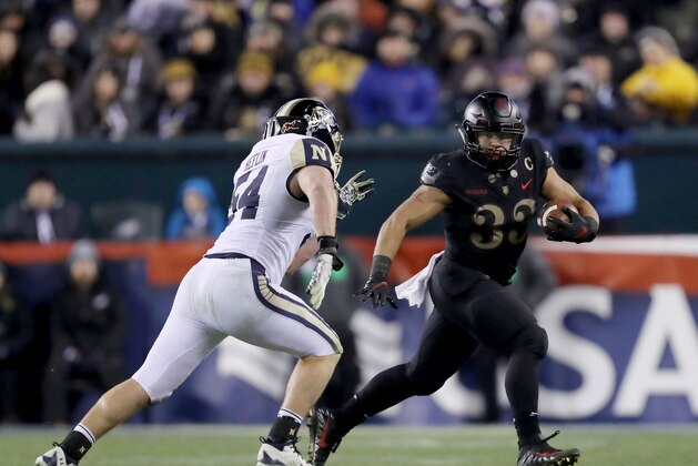PHILADELPHIA, PENNSYLVANIA - DECEMBER 08:  Darnell Woolfolk #33 of the Army Black Knights carries the ball as Taylor Heflin #54 of the Navy Midshipmen defends at Lincoln Financial Field on December 08, 2018 in Philadelphia, Pennsylvania.The Army Black Knights defeated the Navy Midshipmen 17-10. (Photo by Elsa/Getty Images)
