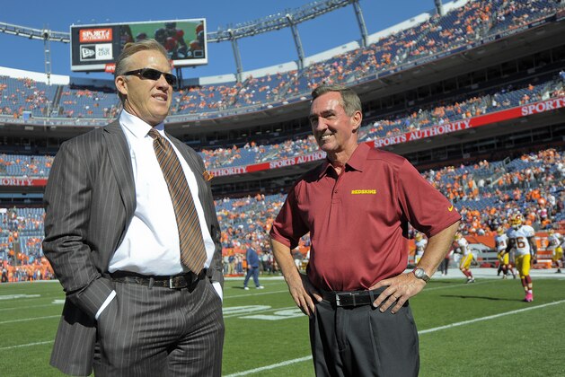 Denver Broncos executive vice president of football operations John Elway, left, talks with Washington Redskins coach Mike Shanahan before an NFL football game, Sunday, Oct. 27, 2013, in Denver. (AP Photo/Jack Dempsey)