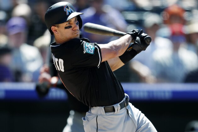 Miami Marlins' J.T. Realmuto follows the flight of his grand slam of Colorado Rockies relief pitcher Bryan Shaw in the seventh inning of a baseball game Saturday, June 23, 2018, in Denver. (AP Photo/David Zalubowski)