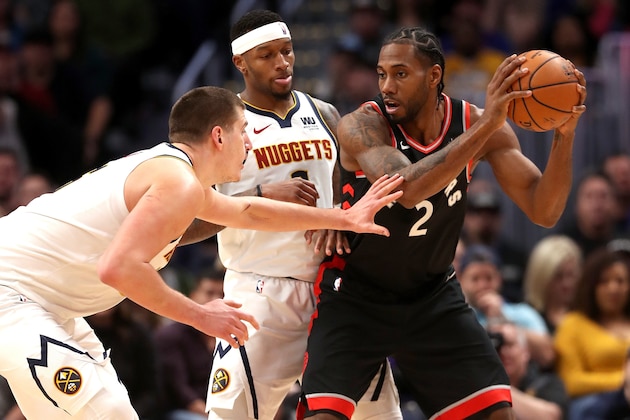 DENVER, COLORADO - DECEMBER 16: Nikola Jokic #15 and Torrey Craig #3 of the Denver Nuggets guard Kawhi Leonard #2 the Toronto Raptors at the Pepsi Center on December 16, 2018 in Denver, Colorado.  (Photo by Matthew Stockman/Getty Images)