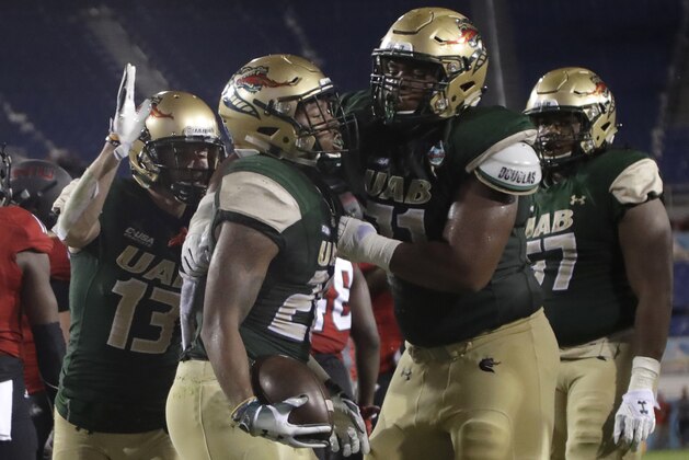 UAB running back Spencer Brown, center, is congratulated by wide receiver Collin Lisa (13) and offensive lineman Rishard Cook, right, after scoring a touchdown during the first half of the Boca Raton Bowl NCAA college football game against Northern Illinois, Tuesday, Dec. 18, 2018, in Boca Raton, Fla. (AP Photo/Lynne Sladky)