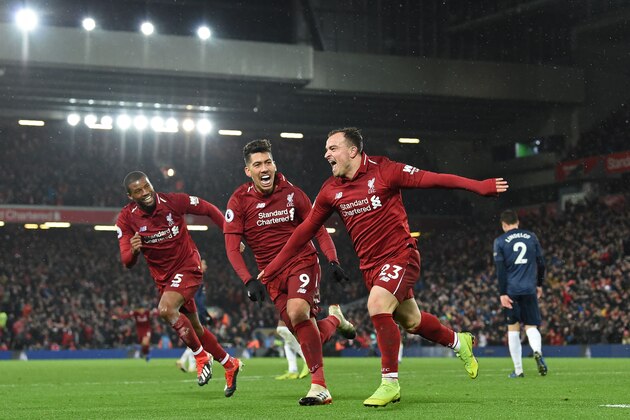 Liverpool's Swiss midfielder Xherdan Shaqiri (C) celebrates with Liverpool's Dutch midfielder Georginio Wijnaldum (L) and Liverpool's Brazilian midfielder Roberto Firmino (2nd L) after scoring their third goal during the English Premier League football match between Liverpool and Manchester United at Anfield in Liverpool, north west England on December 16, 2018. (Photo by Paul ELLIS / AFP) / RESTRICTED TO EDITORIAL USE. No use with unauthorized audio, video, data, fixture lists, club/league logos or 'live' services. Online in-match use limited to 120 images. An additional 40 images may be used in extra time. No video emulation. Social media in-match use limited to 120 images. An additional 40 images may be used in extra time. No use in betting publications, games or single club/league/player publications. /         (Photo credit should read PAUL ELLIS/AFP/Getty Images)