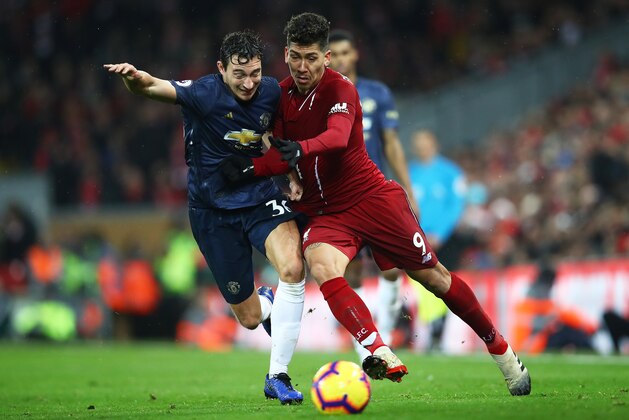 LIVERPOOL, ENGLAND - DECEMBER 16:  Roberto Firmino of Liverpool battles for possession with Matteo Darmian of Manchester United during the Premier League match between Liverpool FC and Manchester United at Anfield on December 16, 2018 in Liverpool, United Kingdom. (Photo by Clive Brunskill/Getty Images)
