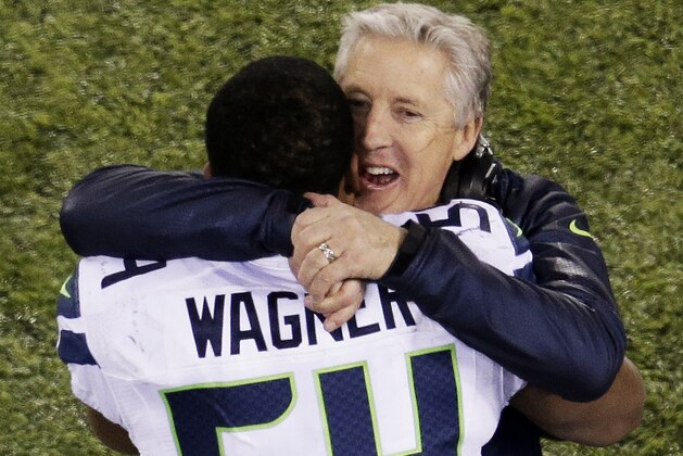 EAST RUTHERFORD, NJ - FEBRUARY 02:  Middle linebacker Bobby Wagner #54 and head coach Pete Carroll of the Seattle Seahawks embrace after their 43 to 8 win over the Denver Broncos during Super Bowl XLVIII at MetLife Stadium on February 2, 2014 in East Rutherford, New Jersey.  (Photo by Win McNamee/Getty Images)
