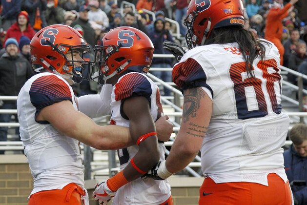 Syracuse quarterback Eric Dungey, left, celebrates with teammates Taj Harris, center, and Airon Servais (68) after Harris caught a pass for a touchdown during the second half of an NCAA college football game against Boston College, Saturday, Nov. 24, 2018, in Boston. (AP Photo/Mary Schwalm)